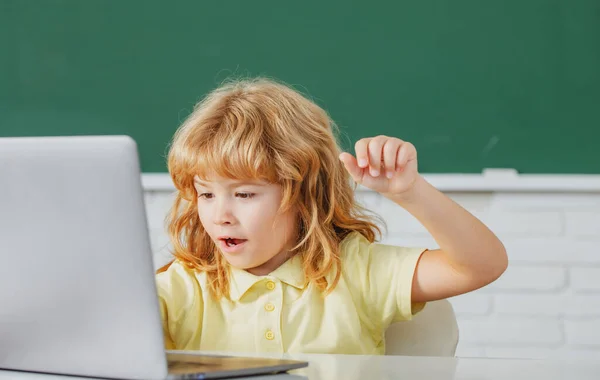 School kind met behulp van digitale pc laptop in de klas. Portret van een grappige leerling van de lagere school studie programmering. Online leertechnologie, virtueel onderwijs webinar. — Stockfoto
