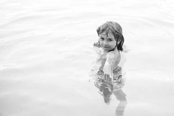 Niño feliz jugando en la piscina. Juegos de agua infantil. Vacaciones familiares y actividad de verano. — Foto de Stock