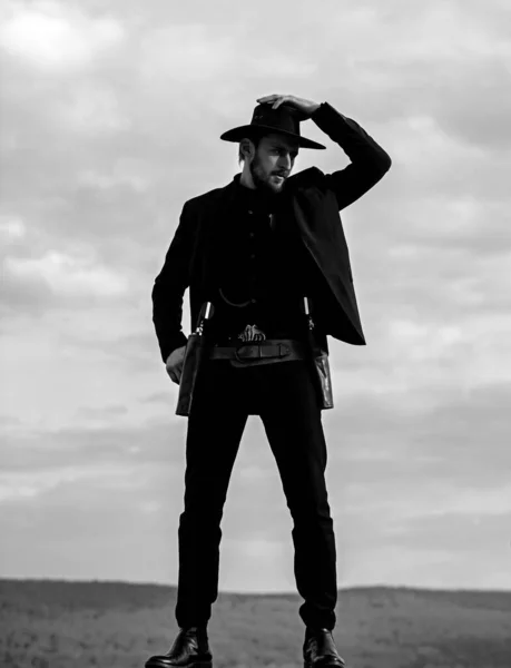 Sheriff o vaquero con traje negro y sombrero de vaquero. Hombre con pistola de revólver West Vintage y munición de mariscal. western americano, sheriff. —  Fotos de Stock