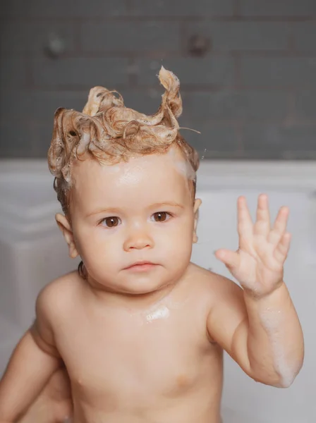 Washing adorable baby in bathroom. Kid with soap suds on hair taking bath. Closeup portrait of smiling kid, health care and kids hygiene. Kid bathing in bathroom. — Stock Photo, Image