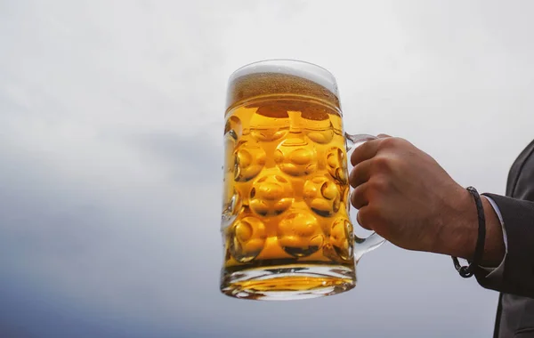 Mužská ruka drží sklenici piva. Pivní džbány. — Stock fotografie