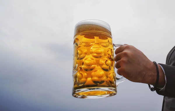 Een man houdt een glas bier vast. Biermokken. — Stockfoto