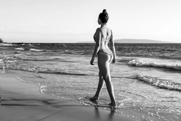 Belle jeune femme marchant en mer sur une plage de sable fin. Voyage d'été. Plage d'été et mer. — Photo