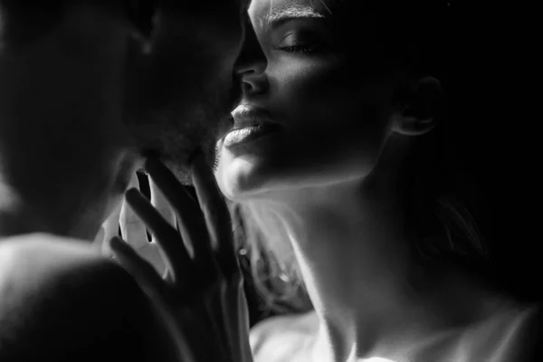 Close up face of sensual portrait of a sexy couple embracing while dating. Young couple in love on black. The lovely coupl spends time together. Sensual couple in the tender passion. — Stock Photo, Image