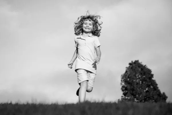 Kind loopt in het park buiten. Lente kind loopt op gras. Zomer jongen. Kinderen zorgeloos. — Stockfoto