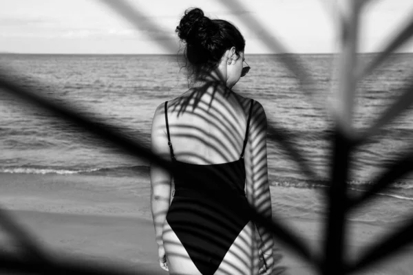Sommar semester av kvinna njuter tropisk strand destination. Flicka avkopplande på karibisk semester. Kvinna och skuggor av palmblad på kroppen. — Stockfoto