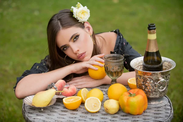 Portrait of woman with fresh fruit on a table in park outdoors. Healthy vegetarian food, healthcare. Sensual young woman and healthy vegetarian food, fruits. Beauty woman face. — Stock Photo, Image