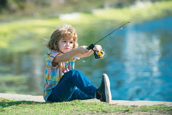 川や湖での子供釣り。若い子供の漁師。夏の屋外レジャー活動。小さな男の子がロッドで川にぶらついて. — ストック写真