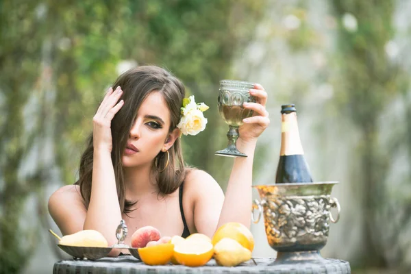 Σέξι αισθησιακή γυναίκα χαλαρώνει και πίνει σαμπάνια. Εξωτική καλοκαιρινή διατροφή, τροπικά φρούτα. — Φωτογραφία Αρχείου