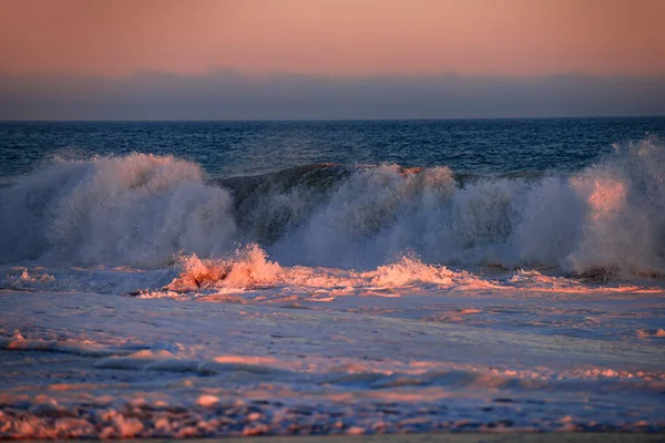Пляжный восход над тропическим морем. Красочный закат с волнами брызг на пляже. Волны океана. — стоковое фото