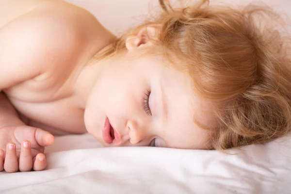 Funny baby child sleeping in the bed. Closeup sleepy kids face. — Stock Photo, Image