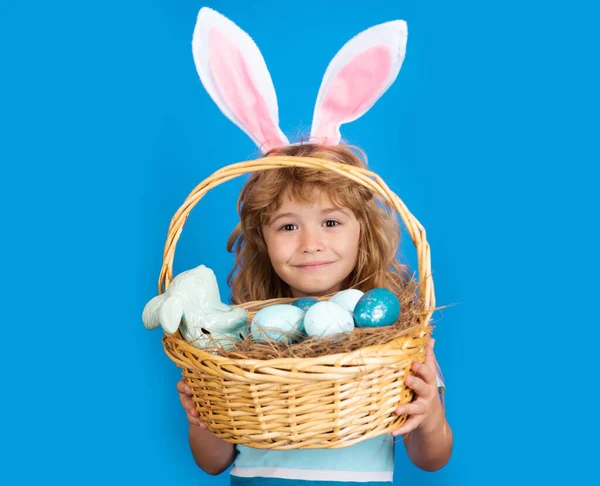 Niño con cesta de Pascua aislado sobre fondo azul. Feliz Pascua. Conejito de Pascua niños. —  Fotos de Stock