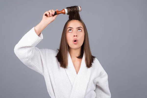 Joven mujer divertida peinando el pelo. Retrato de modelo femenino con un peine cepillando el cabello. Chica con cepillo, cuidado del cabello y belleza. —  Fotos de Stock