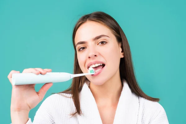 Primo piano sulla giovane donna felice lavarsi i denti. Spazzolino elettrico con dentifricio. — Foto Stock