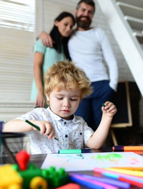 Genç mutlu ebeveynler çocuklu anne baba, aile günü ebeveynlik konsepti. Sevimli çocuklu neşeli üç insan hafta sonları tatilin tadını çıkarıyor. Çocuk resim öğreniyor, küçük sanatçı çiziyor..