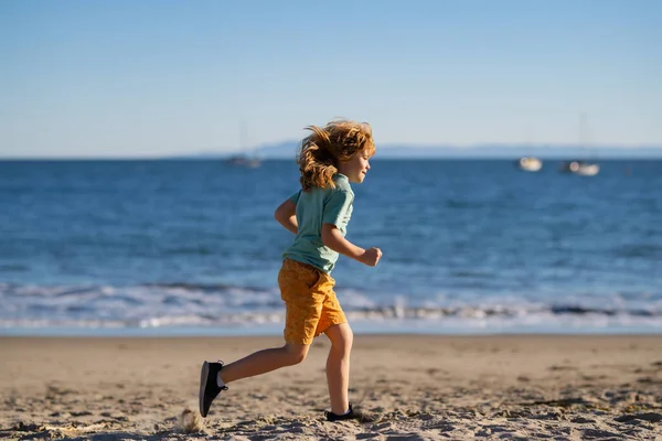 Un chico corriendo en la playa. Niño feliz correr en el mar en vacaciones de verano. —  Fotos de Stock