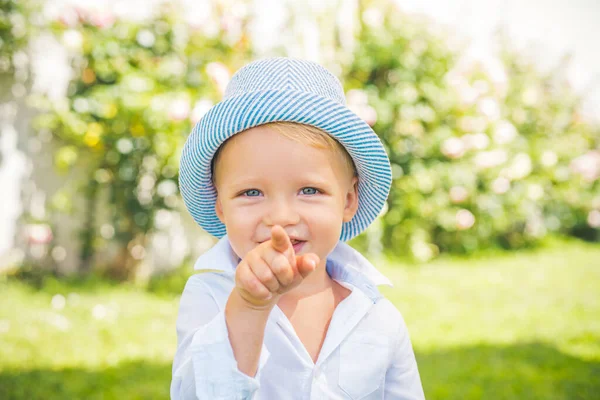 春の公園でかわいい男の子のクローズアップ肖像画。幸せな子供は屋外で楽しんでいます。幼少期の概念. — ストック写真