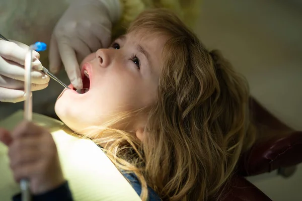 Tannlegekontroll for barns tenner. Tannlege som undersøker små guttetenner på tannklinikken. – stockfoto