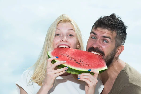 Unga par äter vattenmelon. Porträtt av ett ungt vackert par som äter vattenmelon, Happy coupl ansikte. — Stockfoto