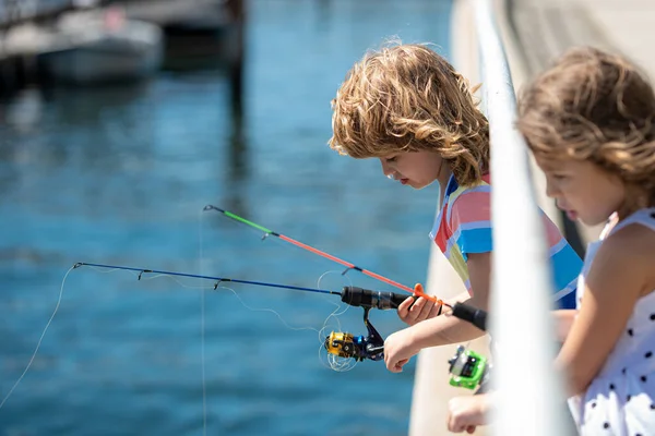 Bambini amici pesca nel fine settimana. Due giovani bambini carini pesca su un lago in una giornata estiva soleggiata. Amicizia. — Foto Stock