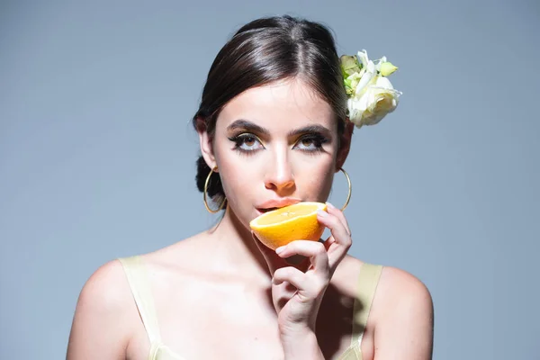 Bastante atractiva divertida comic mujer positiva que tiene piezas de naranja. Retrato de chica sensual sexy sosteniendo mitades de naranja cerca de la cara. —  Fotos de Stock