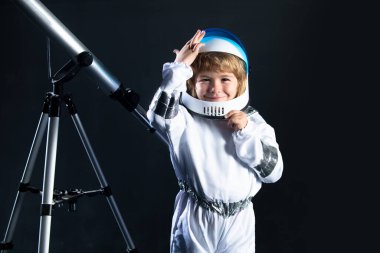Çocuk astronot kaskı ve uzay kostümü giymiş. Uzay giysili küçük çocuk. Yaratıcı fikirler ve yenilik teknolojisi konsepti. Astronot kasklı komik çocuk portresi.