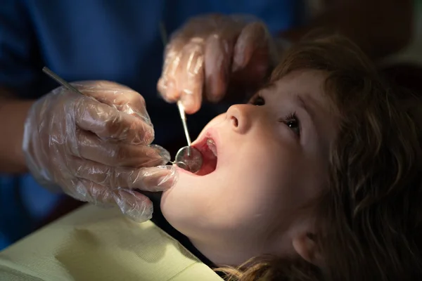 Close-up dentist procedure of kids teeth. A child boy with a dentist in a dental office. Kids orthodontist dentist checking up mouth in dental clinic. Children stomatology.