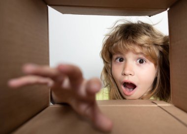 Çocuk bir kutu açıyor ve içine bakıyor, paketleri açıyor, sürpriz bir şekilde boks yapıyor. Şok çocuklar, şaşkın çocuklar duygular, vay canına..