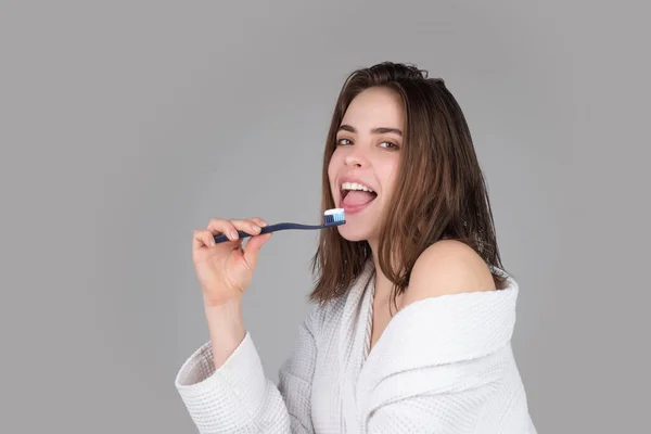 Close-up portret van vrouwen tand glimlach tegen een geïsoleerde achtergrond met kopieerruimte. Meisje dat haar tanden poetst. Mooie jonge vrouw glimlach. Tandheelkundige gezondheid. Witte tand. — Stockfoto