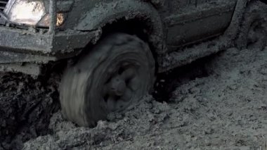 Hasarlı yolda off-car tekerlekleri. Lastikler kötü yolda. Açık hava, maceralar, keşif gezisi ve seyahat cipi. Arabanın tekerlek izlerini kapatın. Tekerleğin yakın çekimi ağır çekimde.