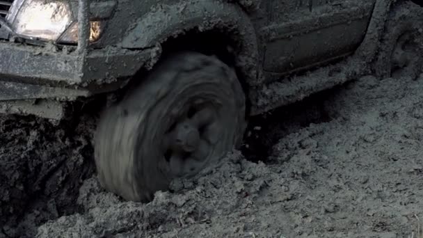 Off road car wheels on damaged road. Tire on bad road. Outdoor, adventures, expedition, and travel suv. Close-up car tyre tracks. Close-up shot of wheel in dirt slow motion. — Stock Video