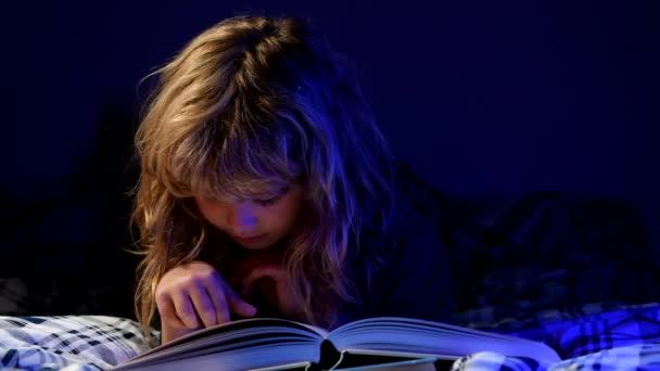 Libro de lectura infantil. Los niños leen libros. Niño sentado en la sala de estar viendo fotos en el libro de cuentos. Un chico haciendo deberes para la escuela primaria. Estudio de niños. — Vídeo de stock