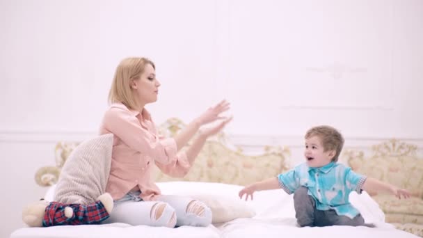 Moeder en kind zoon spelen in bed. Mam en kind praten in de slaapkamer. Moederdag. Moederschap en ouderschap, gelukkige jeugd. — Stockvideo