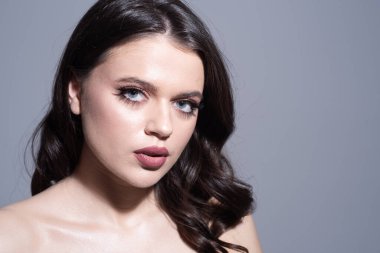 Mavi gözlü güzel esmer kadının stüdyo portresi. Güzel kız yüzü. Gençlik ve cilt bakımı kavramı.