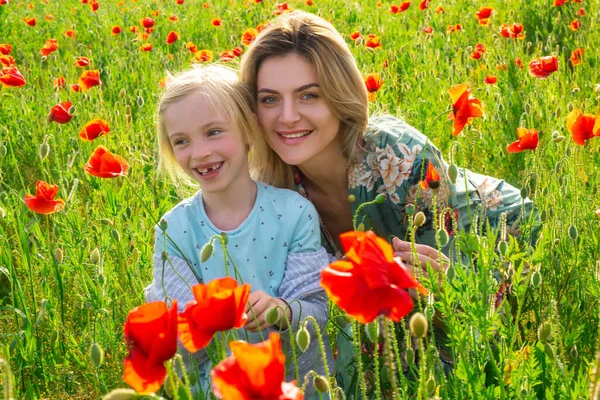 Ritratto di bella bambina con giovane madre indossa abiti casual nel campo dei fiori di papavero. Famiglia sul campo di papavero primaverile. — Foto Stock