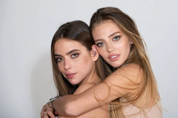 Retrato de dos hermosas mujeres jóvenes sexys abrazándose. Rostros sensuales de dos hermosas mujeres. Retrato de belleza de dos hermanas modelos con piel natural. Lgbt, tolerancia, lesbianas pareja amor concepto. — Foto de Stock