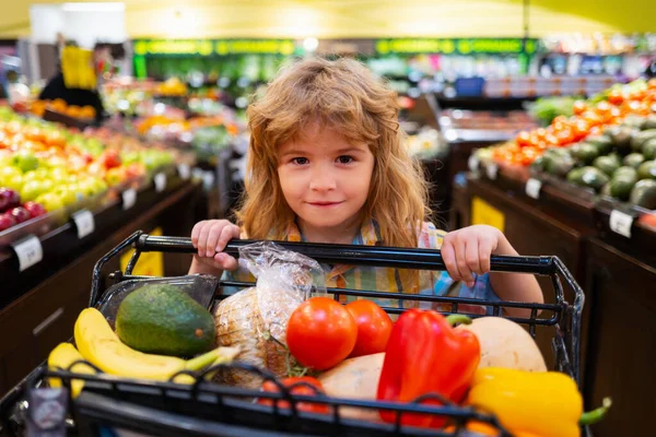 Cibo sano per bambini. Il bambino nel supermercato compra verdure. Shopping per bambini al supermercato. — Foto Stock