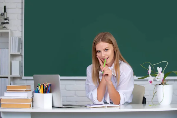 Vrouwelijke student werkt aan een laptop, bereidt zich voor op een examen over het interieur van de school, college klas, klas op de universiteit. Jonge leraar is ervaren leider. — Stockfoto
