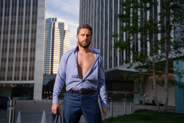 Ελκυστικός άντρας με ανοιχτό πουκάμισο. Σέξι επιχειρηματίας έξω. Ελκυστικός άντρας που βγάζει το πουκάμισο. Αυτοπεποίθηση στην έκκληση του. Όμορφο αντρικό μοντέλο μόδας. — Φωτογραφία Αρχείου