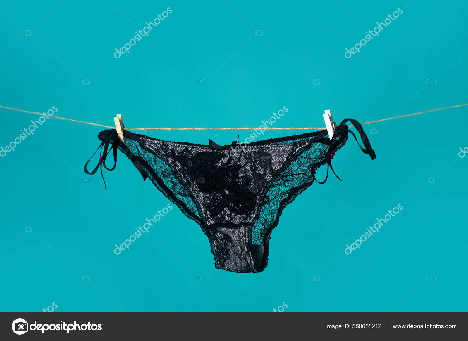 Bragas negras en la cuerda. Ropa interior sexy. Ropa interior de encaje. Mujer bragas eroticas negras. Pantaletas para mujer colgando aisladas sobre fondo azul. Foto de stock 558658212 Tverdohlib