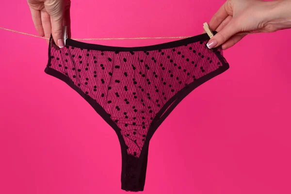Panties. Female lace lingerie. Womans erotic underwear panties. Womans hand hanging on rope erotic black underwear panties. — Stock Photo, Image