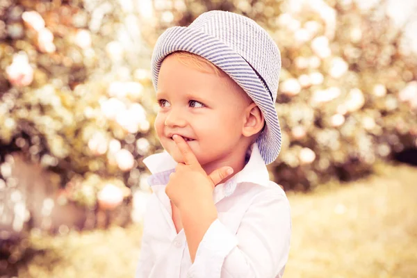 Retrato de cerca de un niño pequeño en el parque de primavera. Chico feliz divirtiéndose al aire libre. Concepto de infancia. — Foto de Stock