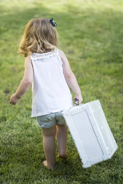 Niña divertida en traje con maleta esperando por el viaje. Viaje conceptual con niños. Pequeño viajero. —  Fotos de Stock