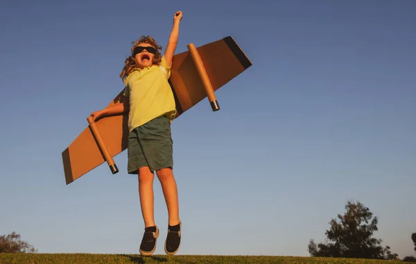 Líder de niños y ganador, arranque de éxito. Emocionado niño jugar con juguete jetpack alas superhéroe en el parque. — Foto de Stock