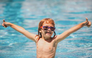 Havuzdaki aktiviteler, yüzen ve suda oynayan çocuklar, mutluluk çocukları ve yaz zamanı. Tatlı çocuk yüzme havuzunda yüzüyor, yazlık su arka planında fotokopi alanı var. Komik çocuk suratı.