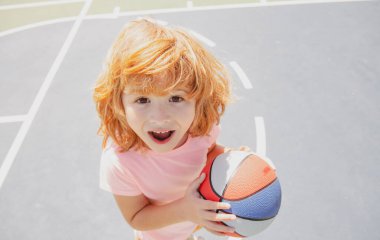 Çocuklar heyecanlı basketbol oynuyorlar, şirin bir çocuğun portresi..