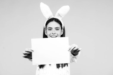 Paskalya tavşanı kız elinde mesaj kağıdı tutuyor. Paskalya tavşanı - kopya alanı, metin konsepti. Boş kağıt.