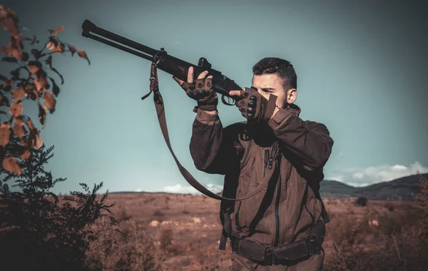 Chasseur avec fusil de chasse en chasse. Calibres de fusils de chasse. Chasseur avec fusil puissant avec des animaux de repérage de portée. Braconnier dans la forêt . — Photo