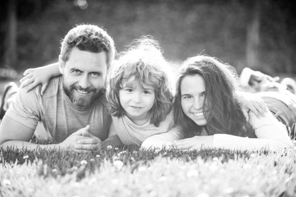Πορτρέτο μιας χαρούμενης οικογένειας που αγκαλιάζεται στο πάρκο. Οικογένεια και παιδί σε εξωτερικούς χώρους το καλοκαίρι φύση. — Φωτογραφία Αρχείου