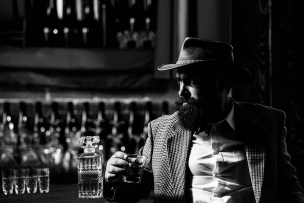 Elegancki i stylowy mężczyzna w klasycznym szkle do noszenia z wiskey w ręku. — Zdjęcie stockowe
